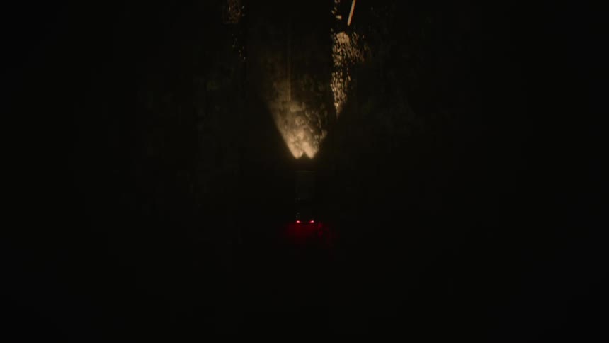 Aerial view of car illuminating road driving on highway at night