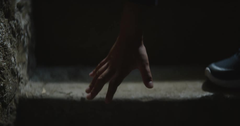 Child standing on steps reaches for fallen sheet of paper