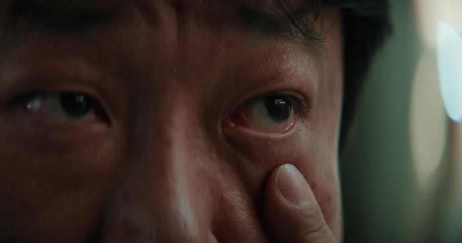 A man puts his finger under his eye and pulls down the skin