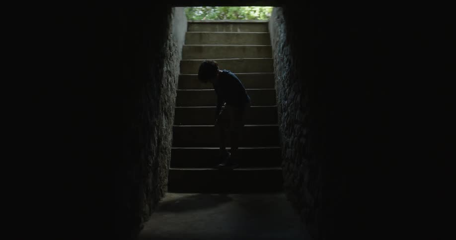Kid sits down on a stairwell