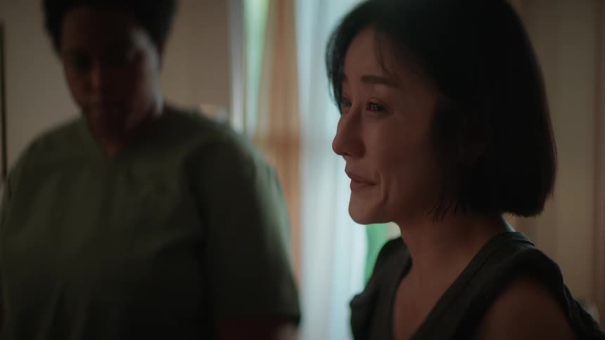 A woman wearing scrubs talks to another woman who appears to be upset about what she was just told