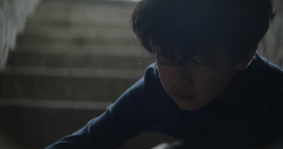 A child reaches for something in the stairwell