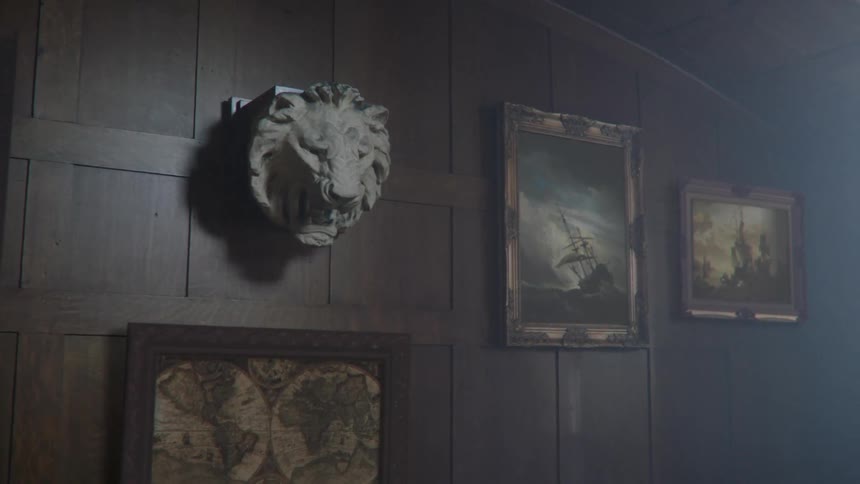 Portraits and a statue bust are hanging on the wall
