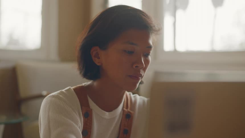 A woman types on her laptop at home