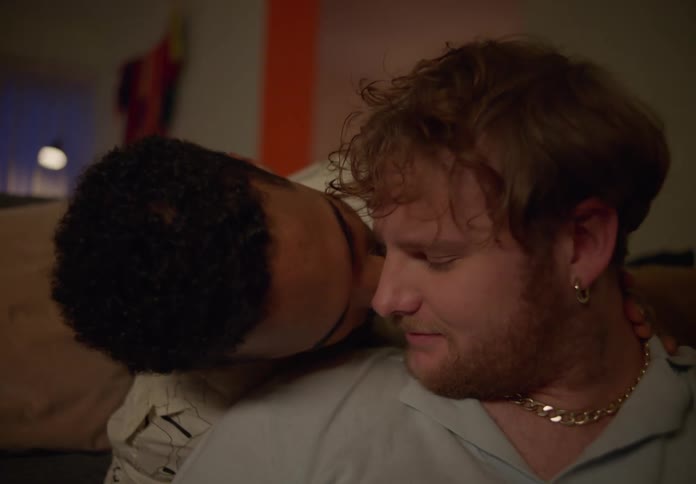 Two men holding each other and looking romantically and sentimentally