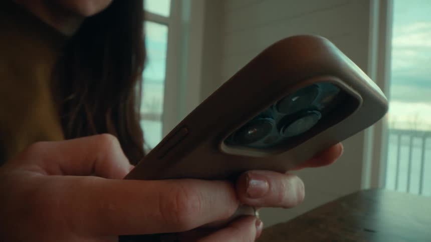 A woman at home texts on her cell phone