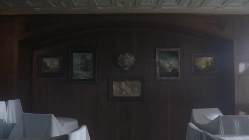 A man turning away from gazing at a wall adorned with paintings and a sculpture
