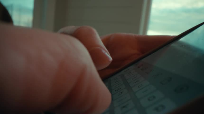 Closeup of a womans hands and thumbs typing on a smartphone screen