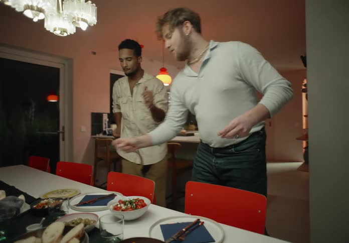 Couple lays the table while dancing in room
