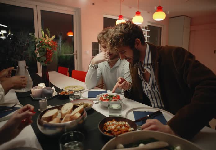 Gay and straight couples sits at table having dinner at night