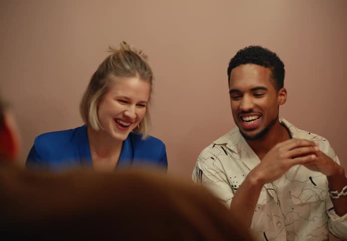 A group of three people are sitting and laughing hysterically