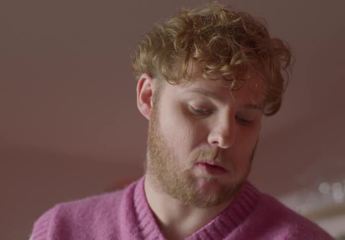 A man eating a piece of toast chewing and looking