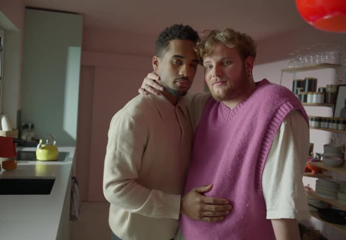 Gay couple holds and strokes each other in the kitchen
