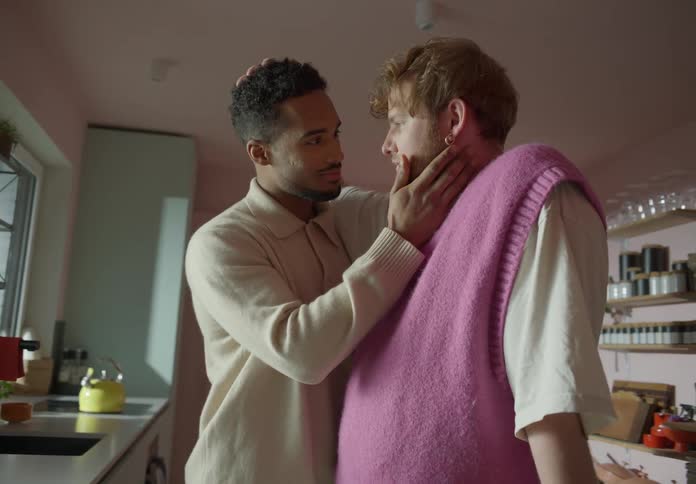 Gay couple touches and strokes each other in the kitchen