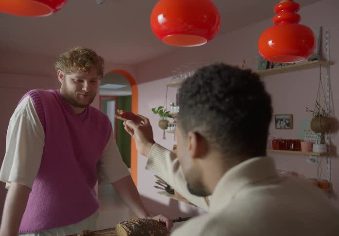 Gay couple eats slices of bread in the kitchen