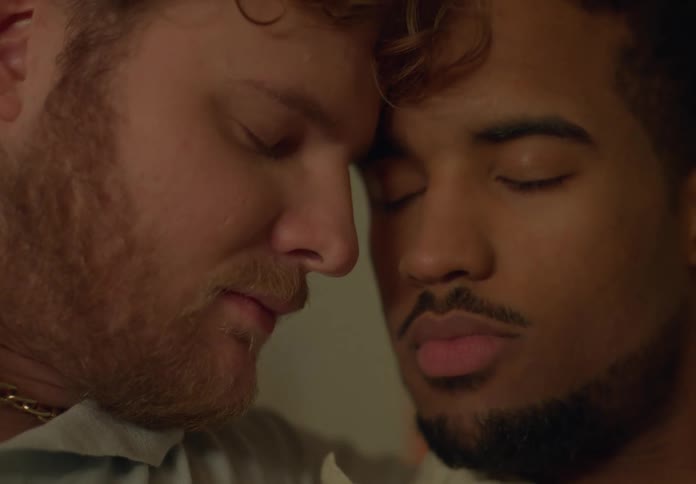 Gay couple holds each other lovingly
