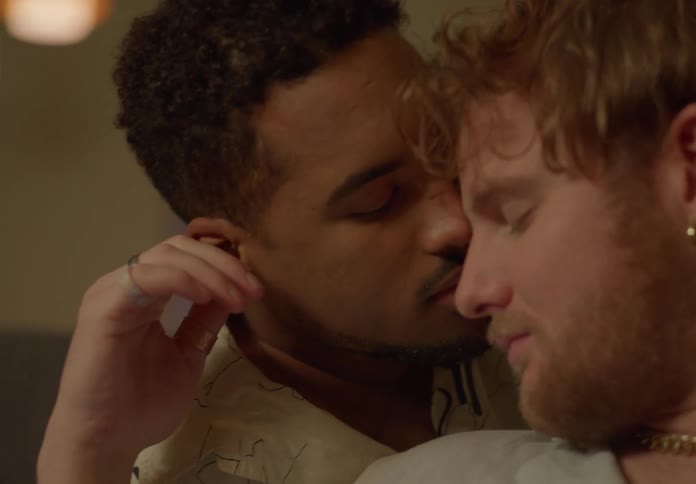 An up close of two mens faces touching romantically