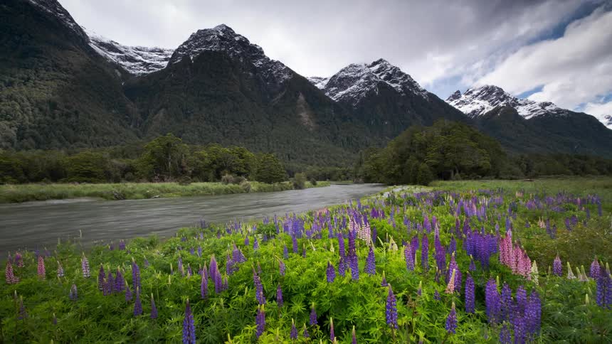 Time lapse view of a river flowing near mountains is displayed