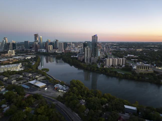 Aerial view of a downtown city near a river is displayed