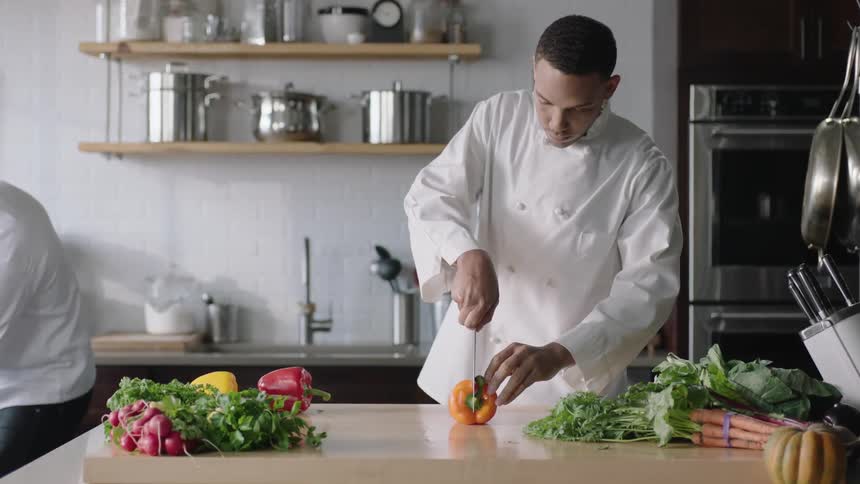 A man is cutting a pepper on a table