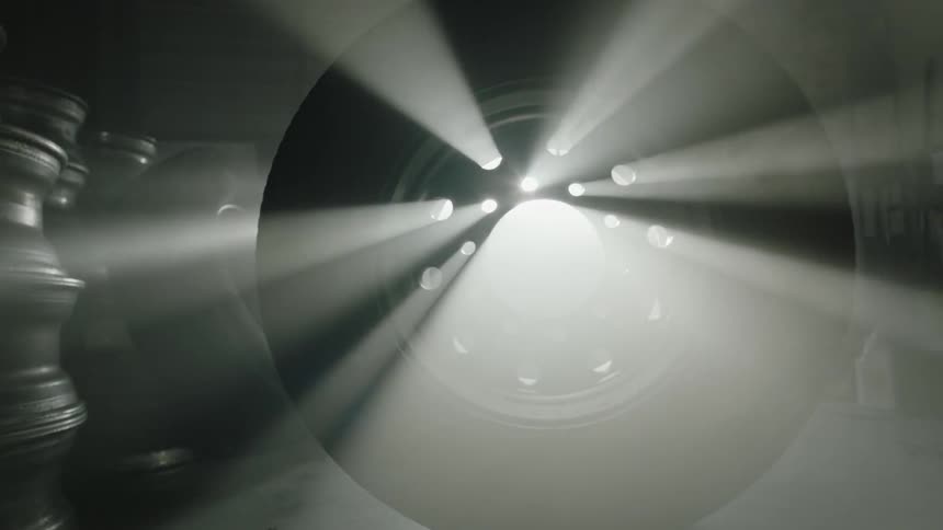 Bright sunlight shines through an automotive wheel standing upright in a garage