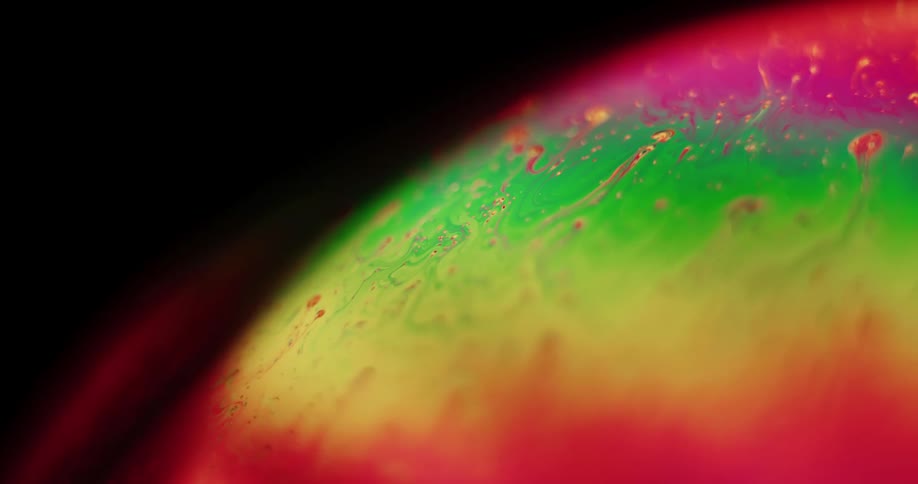 Colorful paint drips down in a spinning sphere