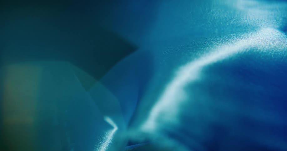 A silken blue fabric floats in water