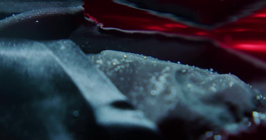 A black silky fabric floats underwater