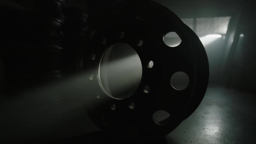Sunlight shining through a tire rim in a dark room