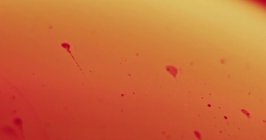 Red particles float across a yellow surface that turns orange as they move
