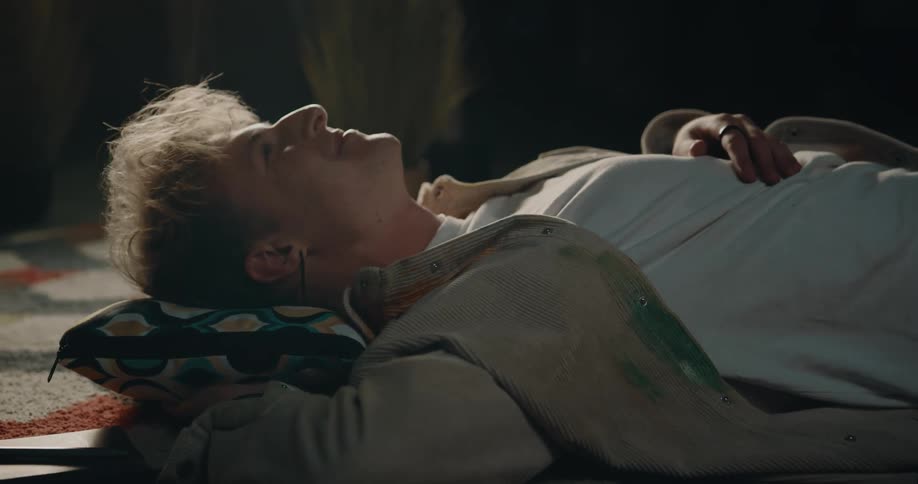 A man is laying down on the ground with a pillow