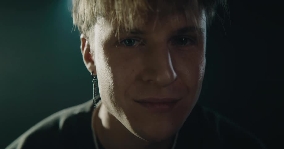 A man is smiling and standing in a room