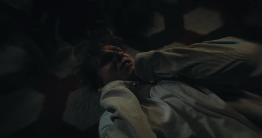 Edgy young man appears to wake up on the floor feeling confused and disturbed maybe hallucinating or hearing voices