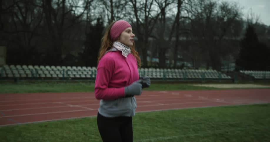 A woman jogs in place while standing on a track