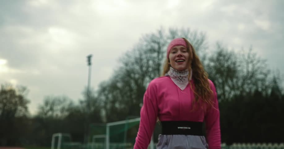 A woman runs down the track and stops to take a breath