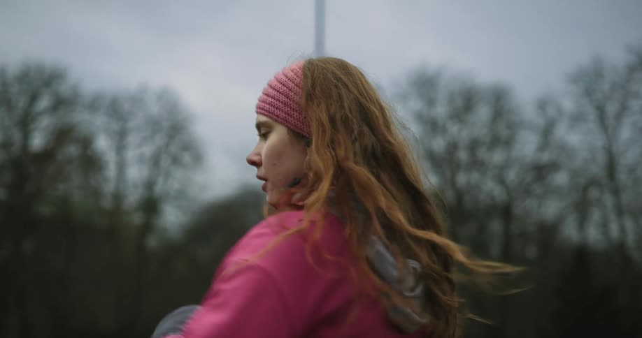 Woman doing a yoga exercise and dressed in a pink jacket