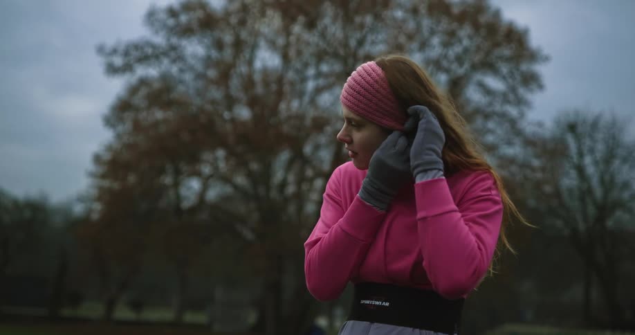 A woman putting in ear plugs for something