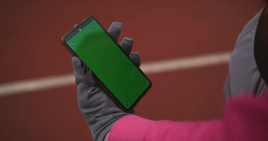 A person using a fake dummy phone that has greenscreen on it