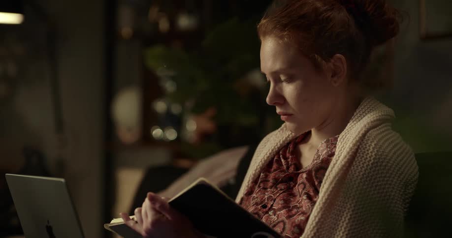 A woman laughs while reading a book
