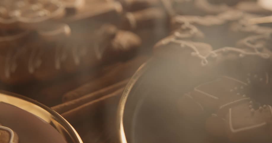 A brown cookie with icing placed on a golden plate breathing out smoke