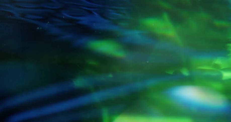 Blue silk fabric moving underwater with green light from above and various reflections abstract