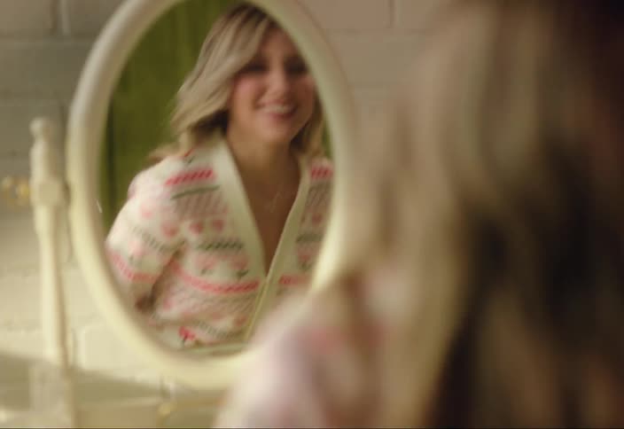 A woman checks her makeup in the mirror