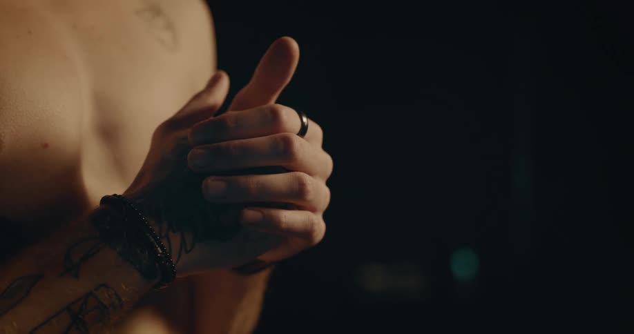 A shirtless man covered in tattoos