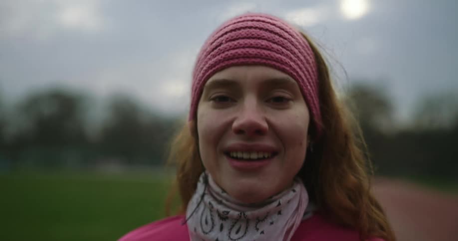 Woman smiles while catching her breath on running track