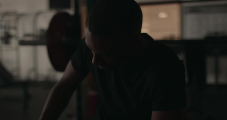 Black man sitting down and taking a breather inside a gym