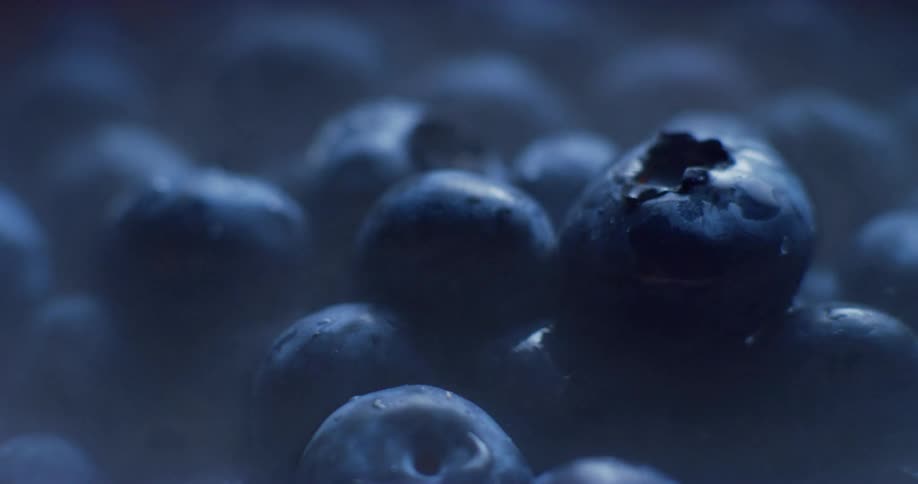 Extreme close up of steam hovering over a pile of ripe blueberries