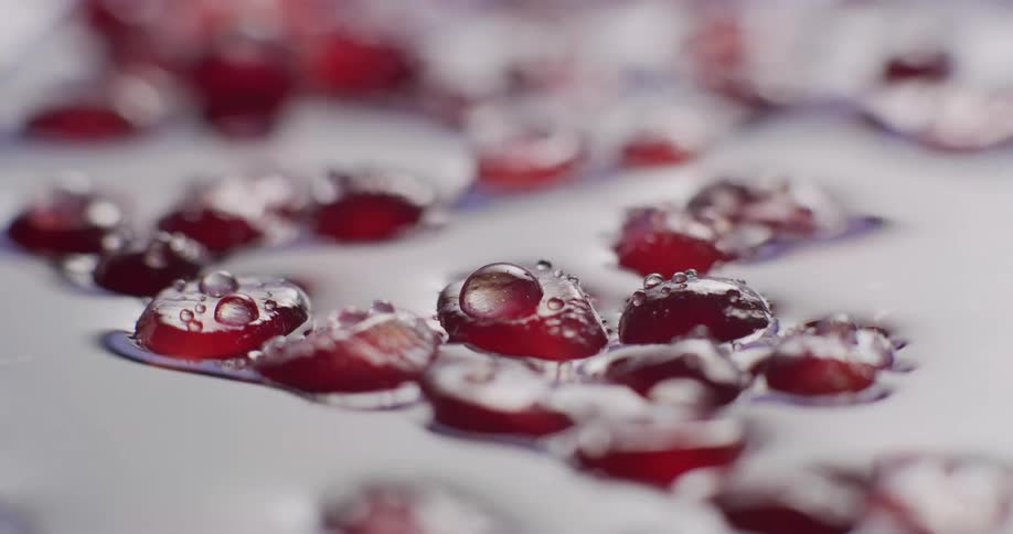 Red berries floating in water shift as liquid trembles