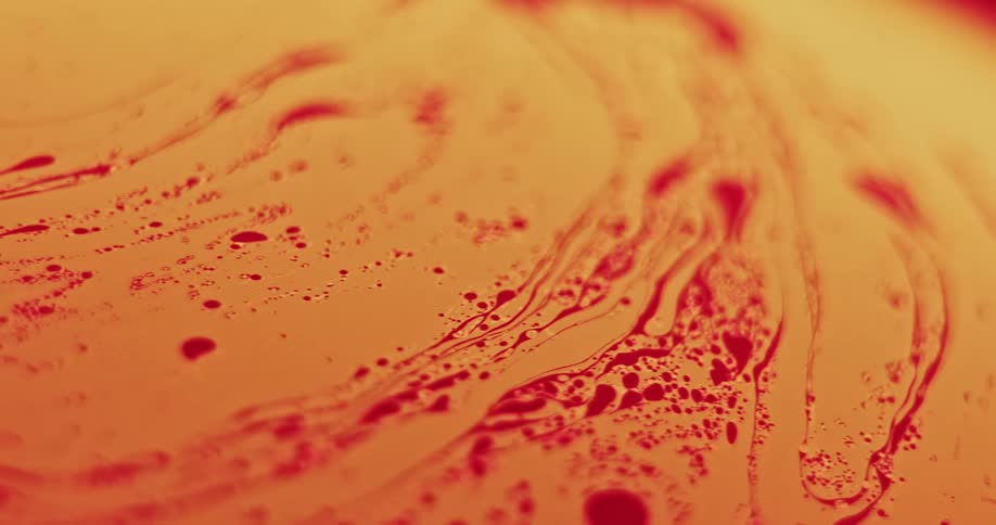 Red splatters blend and move across the organic yellow surface