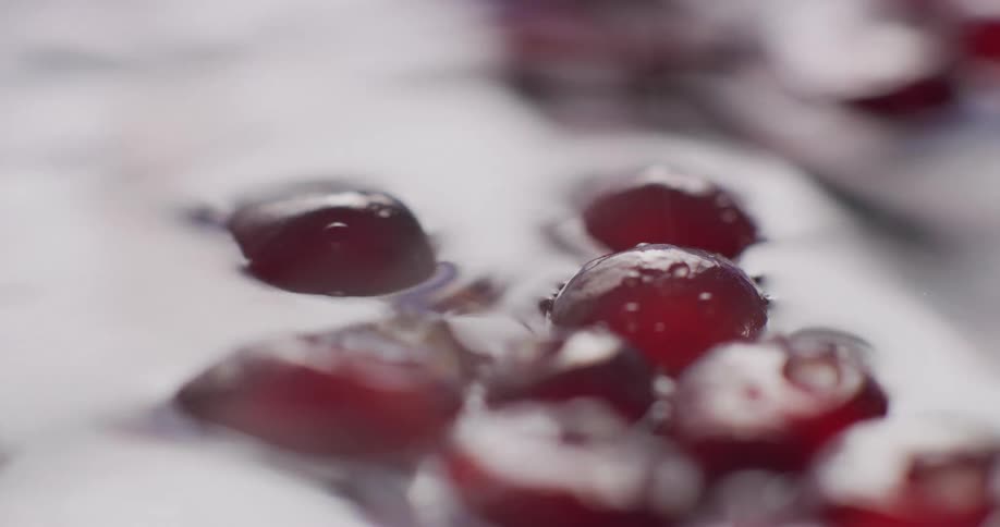 Vapor blows across small red fruit floating in rippling water