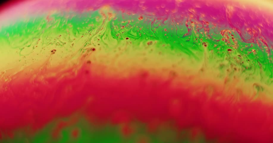 Stripes of fluorescent color move and blend as streaks move across the surface